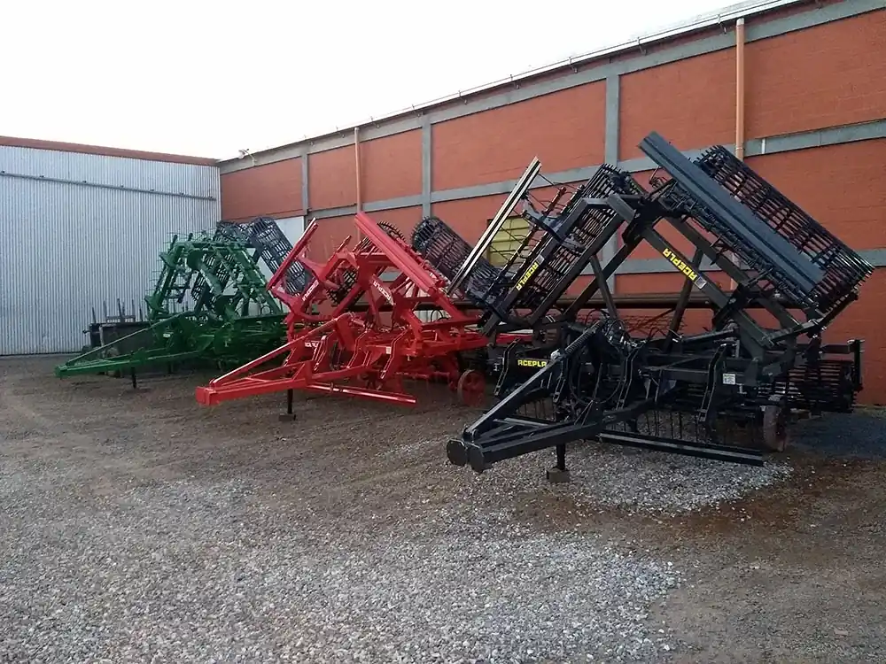 Rastras y rolos ACEPLA terminados, en verde, rojo y negro, estacionados en el playón de la fábrica