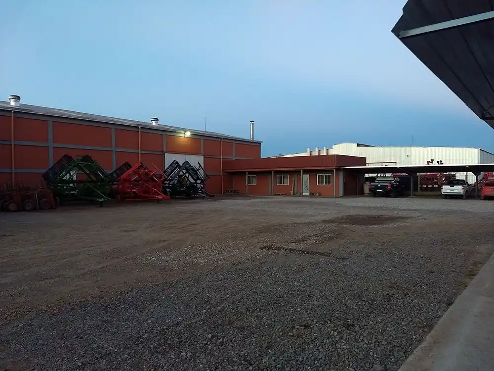 Frente de la planta de ACEPLA al atardecer, con implementos listos para entregar